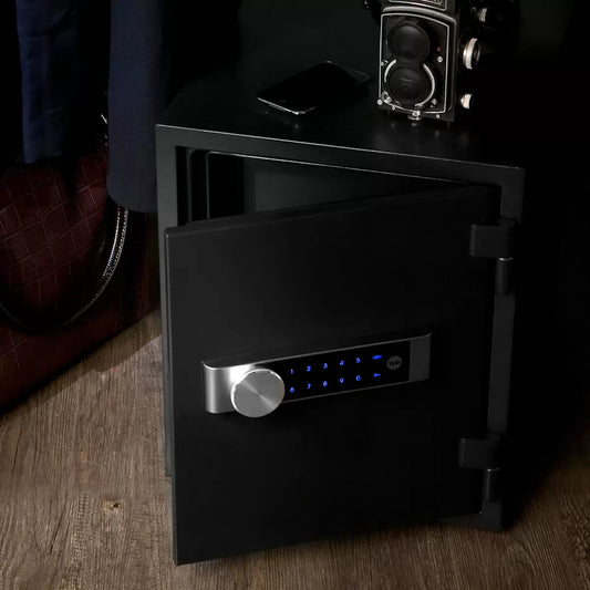 Front view of a charcoal grey Yale extra large fire safe featuring an illuminated digital touch keypad and solid steel handle, resting securely on a modern wooden office floor.