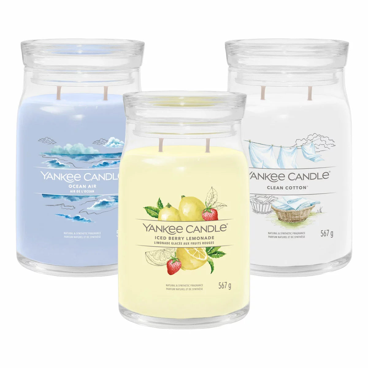 Three large minimalist Yankee Candle jars in ocean breeze, clean cotton, and iced berry lemonade scents arranged on a natural oak table under soft, warm lighting.