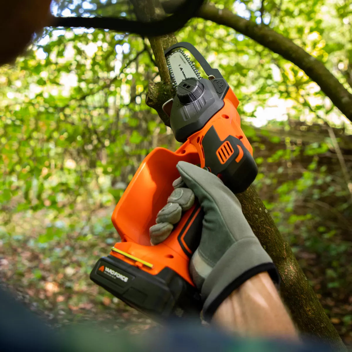 Cordless Yard Force mini chainsaw cutting garden branches outdoors safely - 2