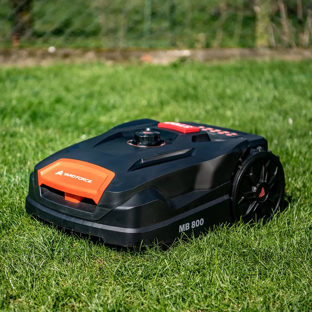 Yard Force MB800 robotic lawnmower with charging station automatically mowing a residential garden up to 800 square metres