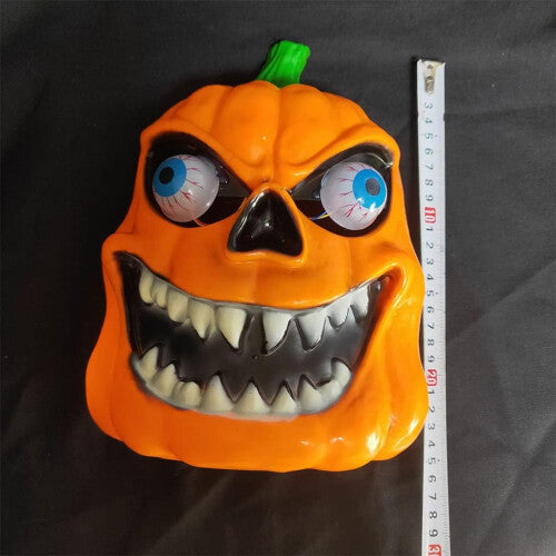 Yellow LED light-up scary Halloween mask with vivid illuminated criss-cross stitching set against a dark, pitch-black background.