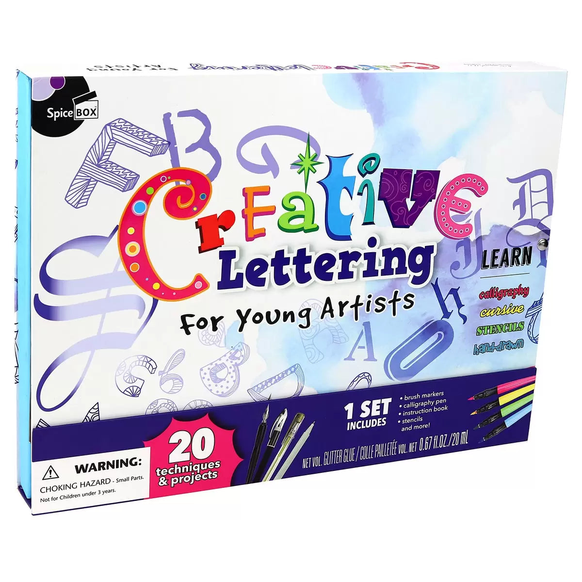 Young Artist Creative Lettering box open on a wooden desk showing brush markers, dip pen with ink bottle, stencils, and a completed colorful calligraphy pad.