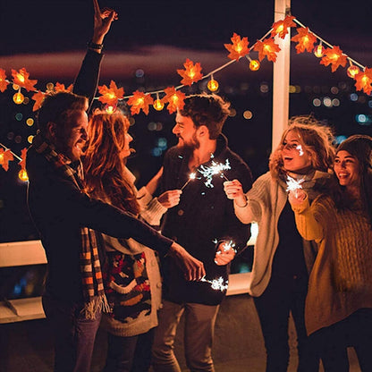 A 20 LED ZOELNIC orange maple leaf string light glowing warmly along a decorated wooden porch railing.