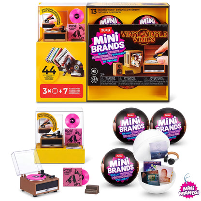 Three colorful ZURU Mini Brands mystery capsules set next to a tiny working black and red mini record player with mini vinyl records spread across a white surface.