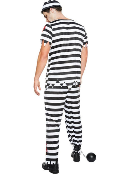 Front view of adult wearing a tattered black and white striped zombie convict costume with bloody splatters in a dimly lit studio setting.