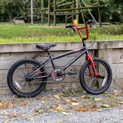Side profile of the black Zombie Plague 18-inch junior BMX bike showing the 10-inch steel frame, alloy wheels, and installed rear stunt peg on a concrete surface.