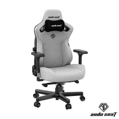 Front angle view of the grey linen fabric anda seaT Kaiser Series 3 large gaming chair showing the magnetic neck pillow and 4D armrests in a brightly lit modern office setup.