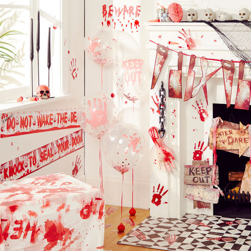 Realistic bloody handprint static cling stickers displayed on a clear glass window during a Halloween setup.