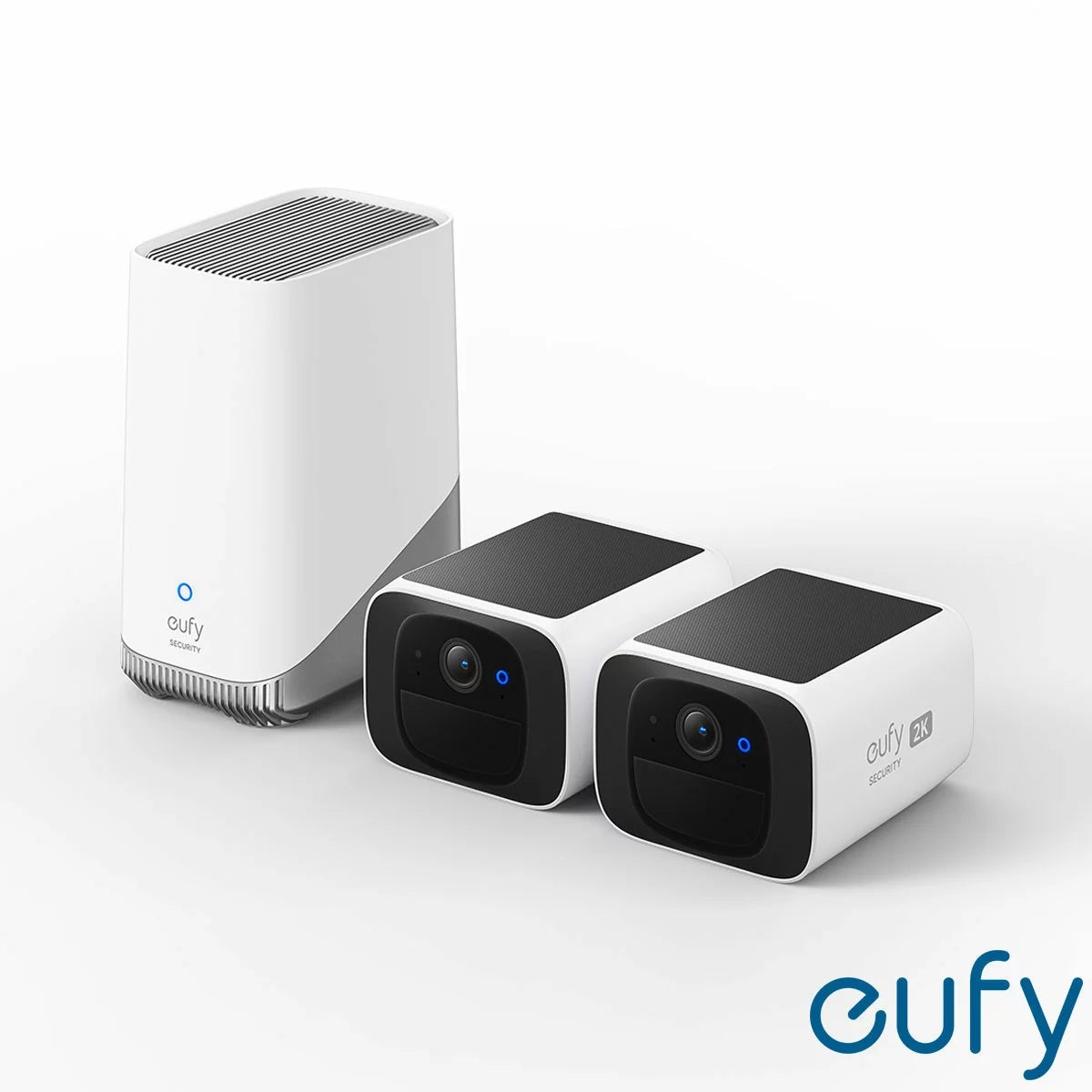 Pair of ultra-compact white eufy SoloCam S220 solar security cameras next to a black eufy HomeBase S380 hub on a light surface.