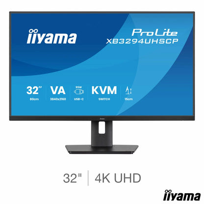 A sleek matte black 32-inch iiyama ProLite 4K professional monitor with thin bezels sits on a minimalist wooden office desk, showcasing a crisp multi-window data layout in a bright studio.