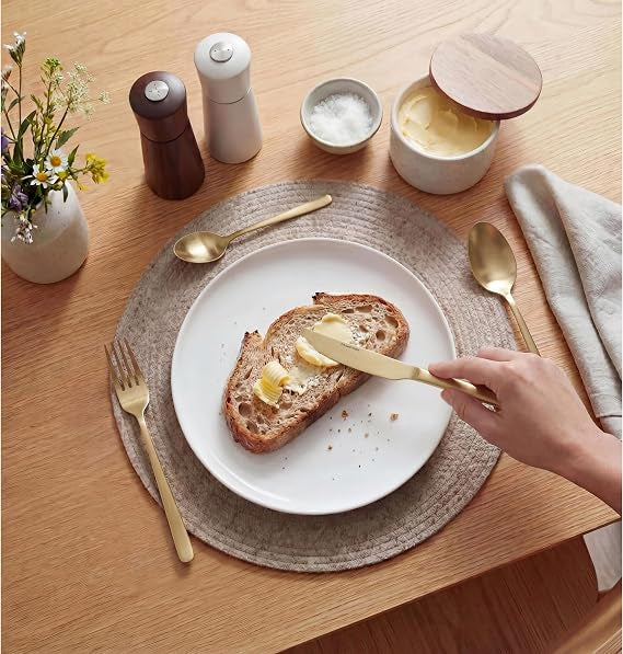 Top-down view of the 32-piece Russell Hobbs Vienna gold satin stainless steel cutlery set neatly arranged on a dark wooden table setting.