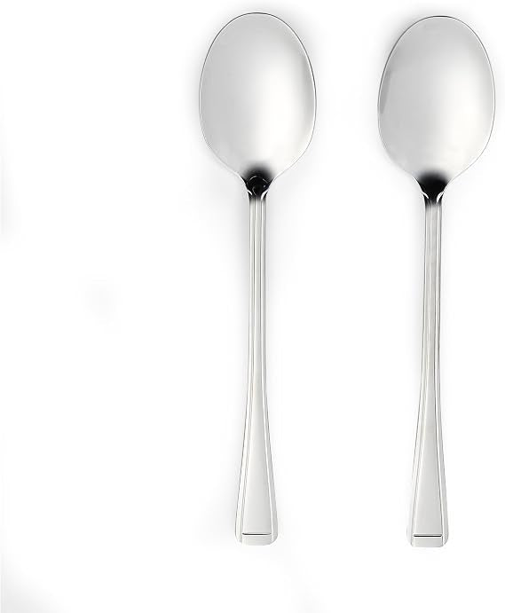 Four-piece Salter Buxton mirror polish stainless steel serving spoon set arranged on a dark wooden dining table next to a salad bowl.