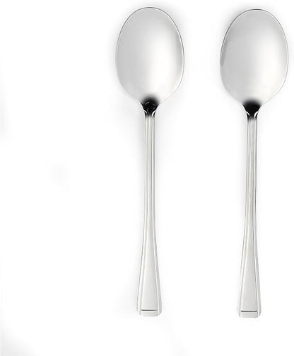 Four-piece Salter Buxton mirror polish stainless steel serving spoon set arranged on a dark wooden dining table next to a salad bowl.