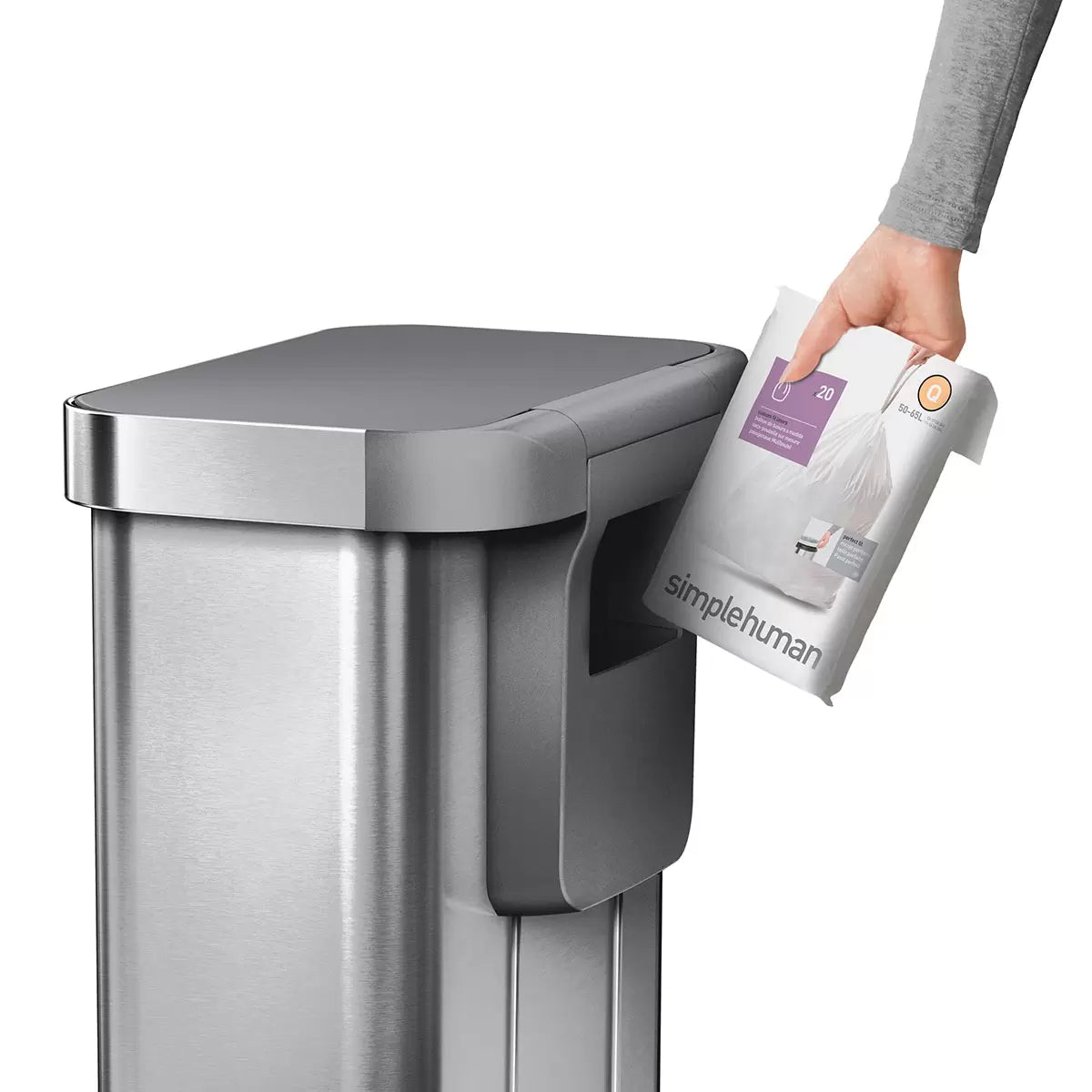 Front angle view of the simplehuman 55L brushed stainless steel step bin with grey plastic lid set against a bright modern kitchen backdrop.