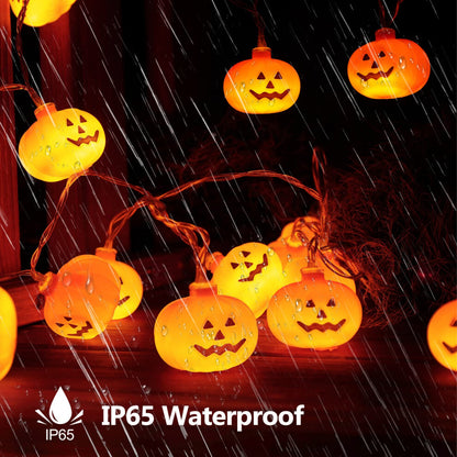 A 3-meter string of 20 mini pumpkin LED lights glowing warmly on an outdoor garden patio wooden fence.