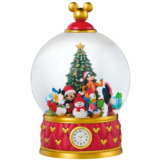 A large, heavy-duty Christmas snow globe featuring intricately sculpted holiday characters, resting on a wooden surface with swirling glitter illuminated by warm internal LED lights.
